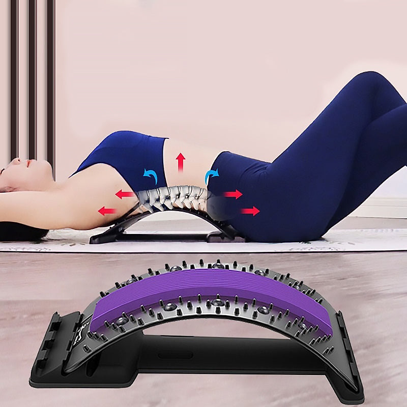 Woman using a lumbar back massager for spinal health and relaxation on a yoga mat.